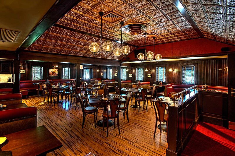 Main dining room with multiple set tables and booth seating