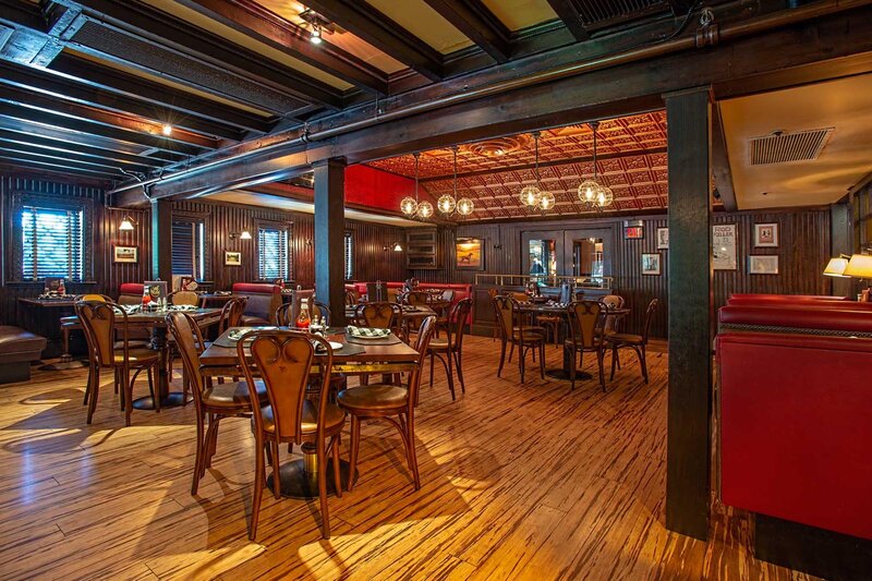 Main dining room with four set tables and multiple seating booths